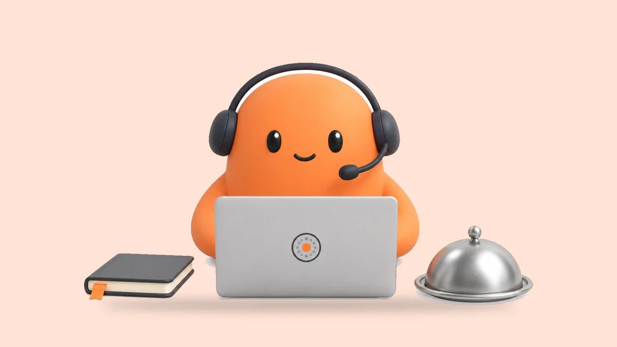 Mia in a headset at a laptop beside a small reservation book and a covered serving dish
