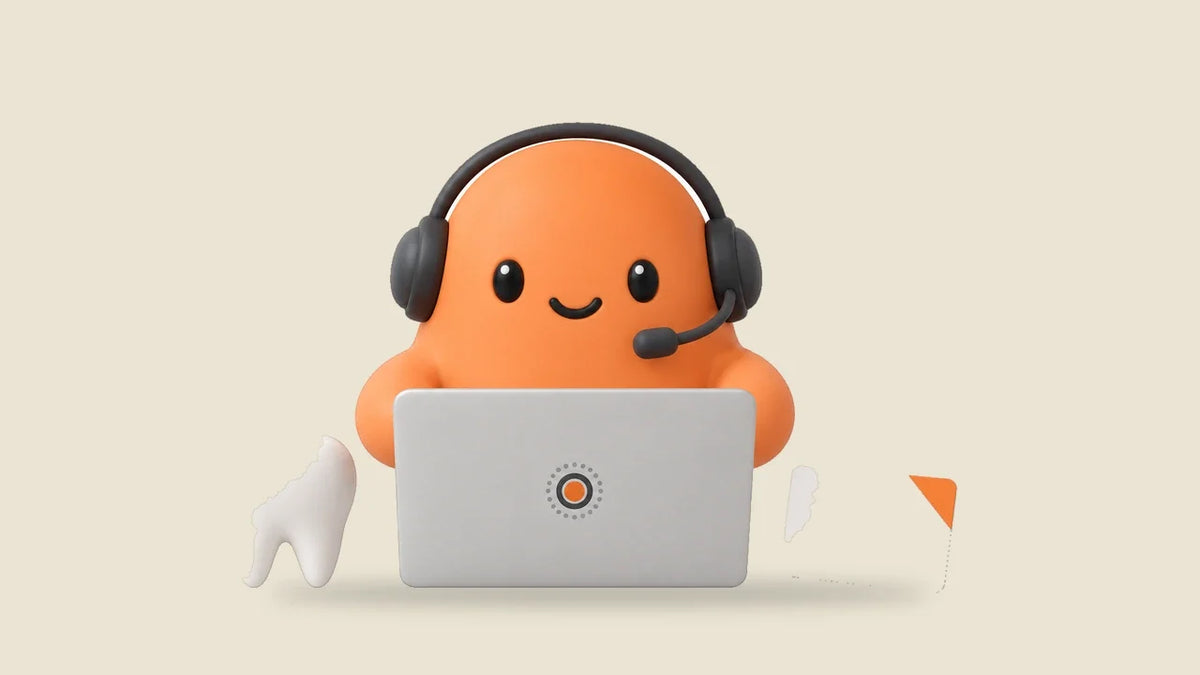 Mia in a headset at a laptop beside a small model tooth and an appointment card