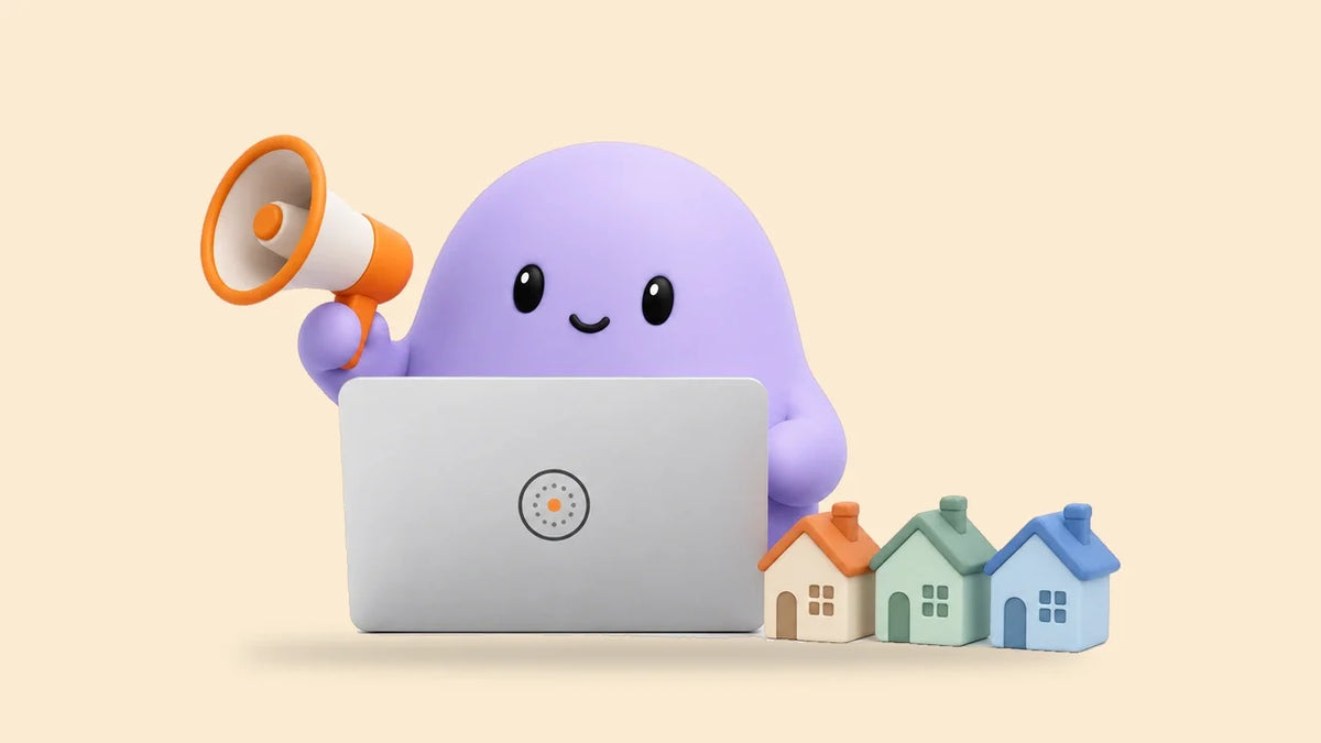Reggie at a laptop beside three small toy houses with different roofs
