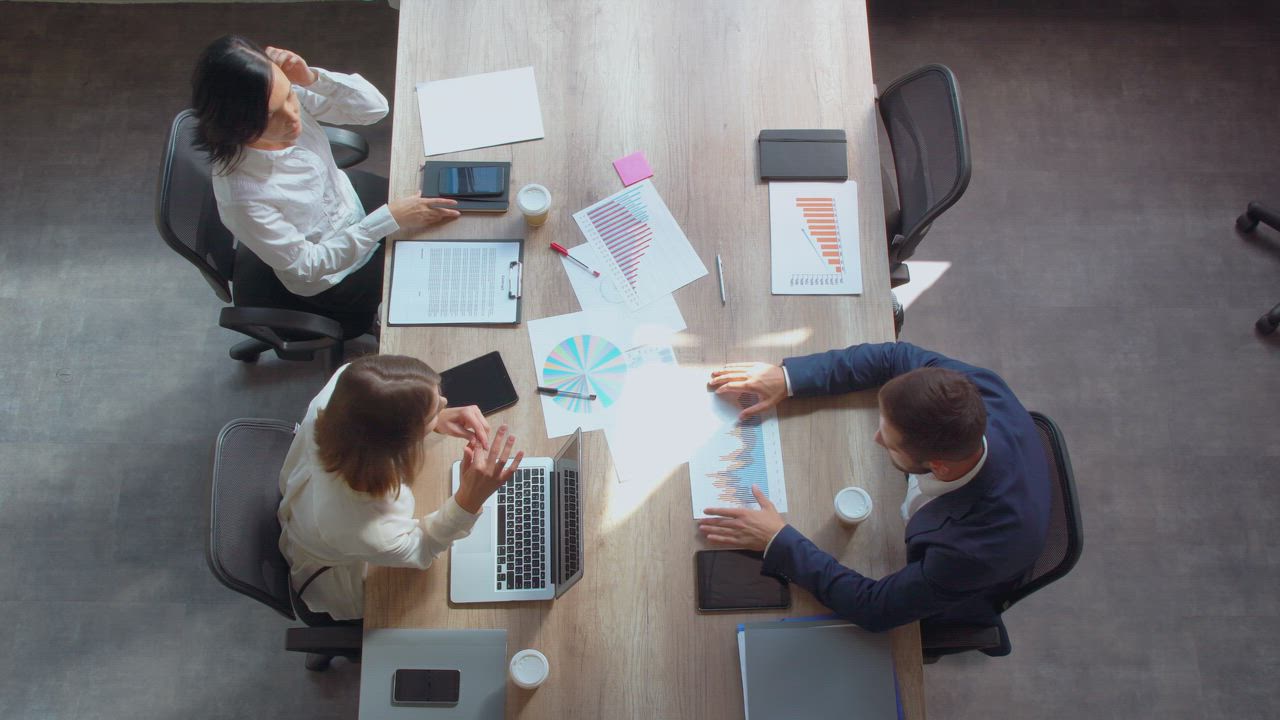 Business team reviewing a shared workflow around a table